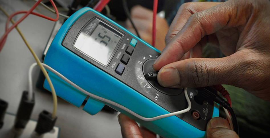 hands using a multimeter hands using a multimeter