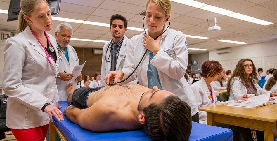 Student using stethoscope on patient Student using stethoscope on patient