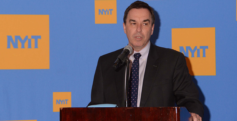 Dr. Jerry Balentine, dean of NYITCOM, at a podium Dr. Jerry Balentine, dean of NYITCOM, at a podium