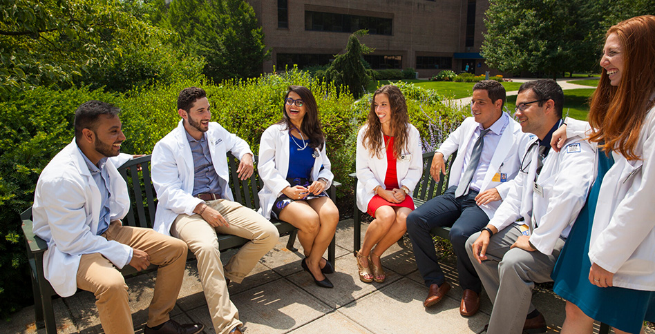 Medical students sitting on benches outside