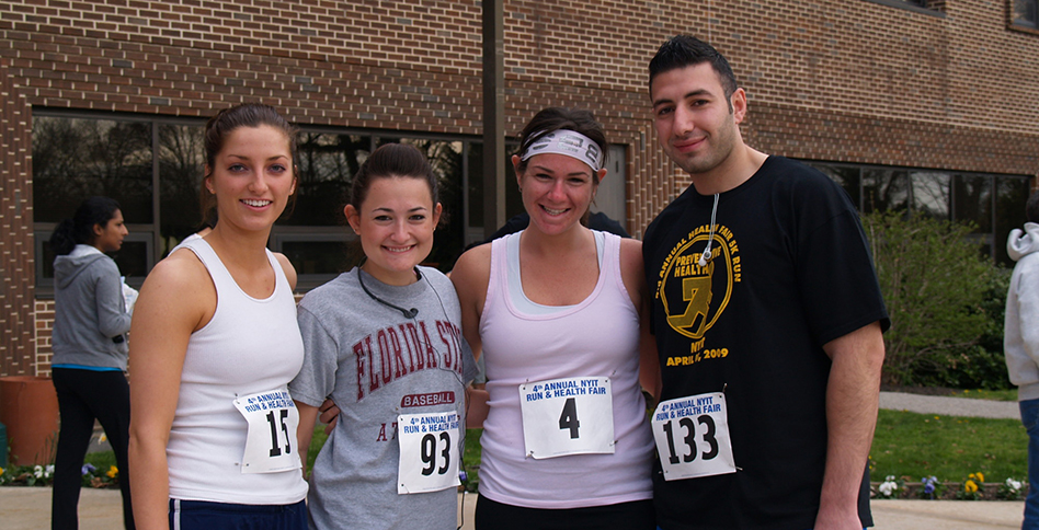 Four students posing with race numbers pinned on