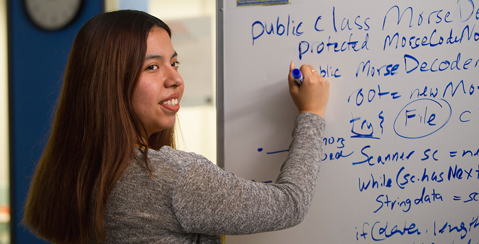 Student writing at whiteboard