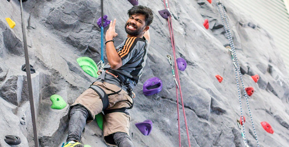 Student climbing an indoor rock wall