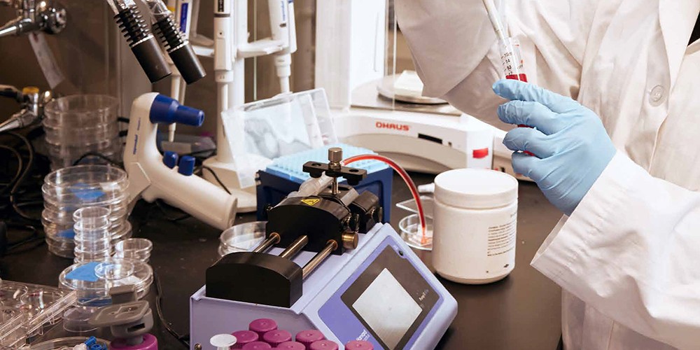 Hands using lab equipment.