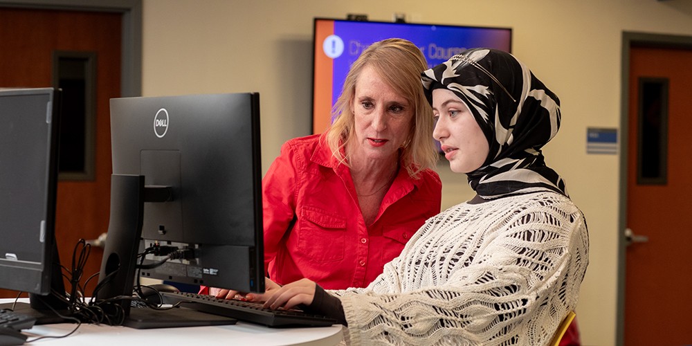 Two women talk over computer.