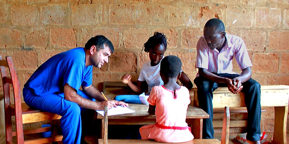 Doctor taking notes on children patients.