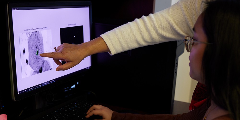 Hand pointing at screen diagram