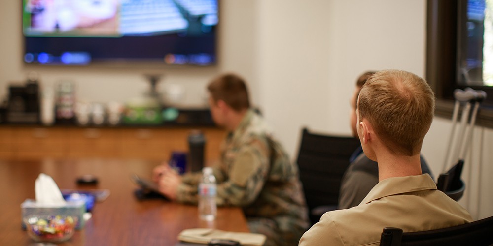 Men in uniform looking at screen