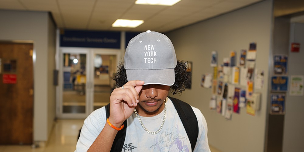 Student wearing New York Tech baseball cap