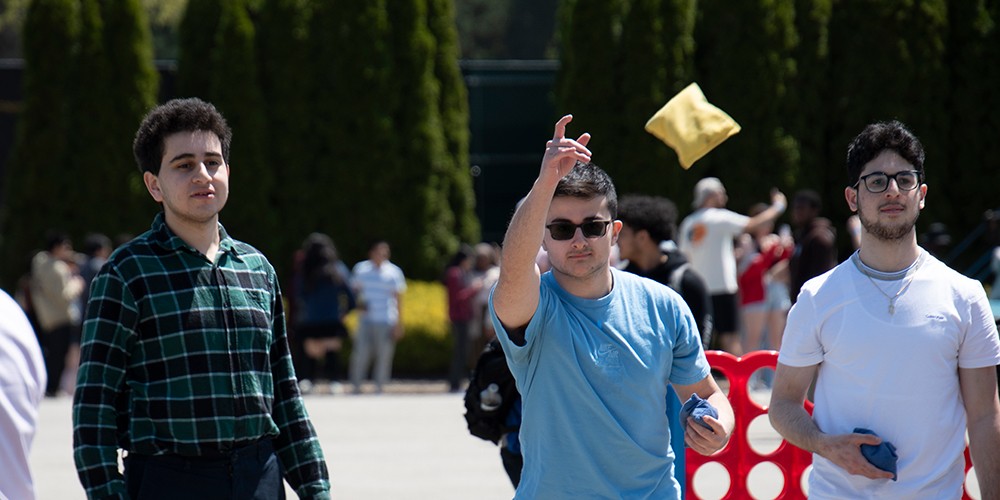Students playing cornhole.